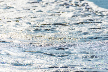 close up of the sea water affecting the sand on the beach, sea waves calmly flowing sand, relaxing view