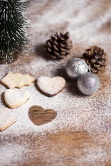 christmas cookies on wooden table with pinecone and decorative ornament