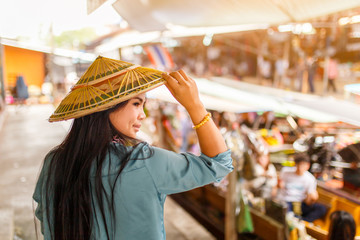 Close up portrait young asian woman with Damnoen Saduak floating market background, Ratchaburi Province, Thailand