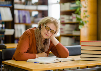 Tired old woman sleep in the library