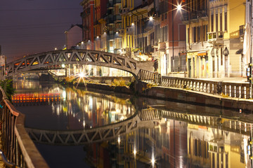 Naklejka premium Bridge across the Naviglio Grande canal at night, Milan, Lombardia, Italy