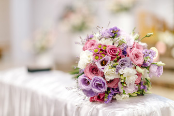 Wedding bouquet of flowers photographed in a very light church.