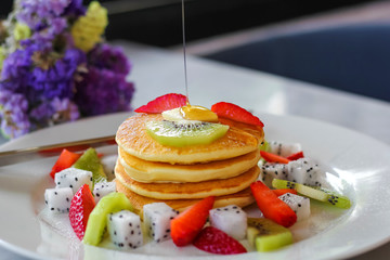 Pancakes for breakfast topped with strawberry and kiwi