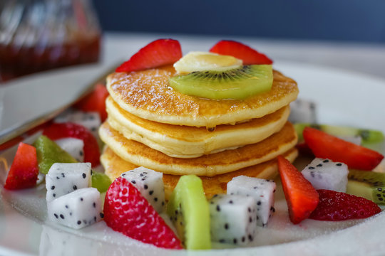 Pancakes for breakfast topped with strawberry and kiwi