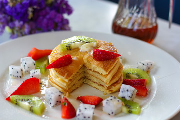 Pancakes for breakfast topped with strawberry and kiwi