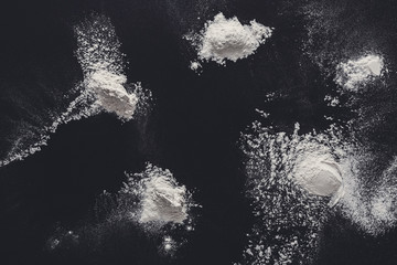 Sprinkled wheat flour splash spots on black background