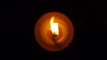 Fototapeta premium burning flat candle at night isolated on dark background