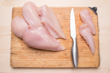 Preparation of a dietary dinner. Fresh chicken fillet, knife