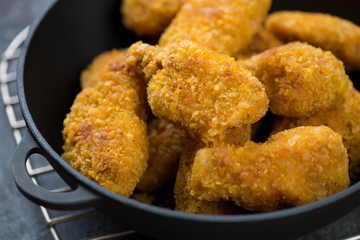 Close-up of roasted breaded chicken wings, selective focus, horizontal shot