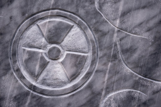 A stone texture with a warning sign of radiation applied. danger.