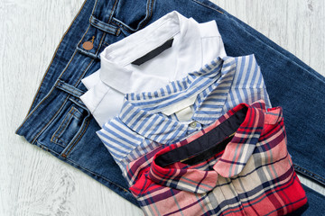 Three shirts on jeans, white, checkered, striped. Collage. Fashionable concept.