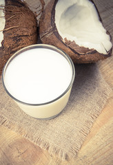 Coconut with coconut milk on wooden background.