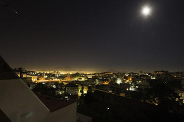 nighttime panorama of Naples with Vesuvio and a full moon