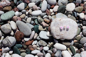 The word Goa on the pebbles on the sea shore