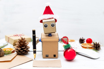 Robot will write congratulations on the card with Christmas and keeps the Christmas tree toy