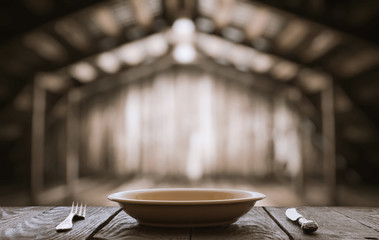empty plate with fork and knife on wooden table