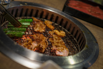 Beef on a plate with grilled BBQ sauce. Grill yakiniku buffet restaurant. subject is blurred.