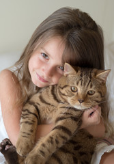Portrait of little girl holding her cat