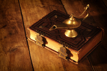 Image of magical aladdin lamp and old books. Lamp of wishes.
