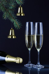 Шампанское и украшенная ель на чёрном фоне для празднования Нового Года.