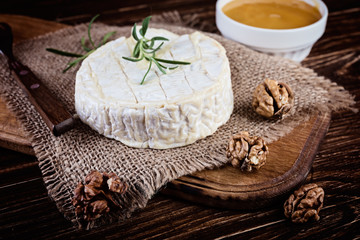 Fototapeta na wymiar Camembert cheese with nuts and honey. Selective focus