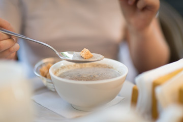 Girl eating cream soup with croutons,crackers toast