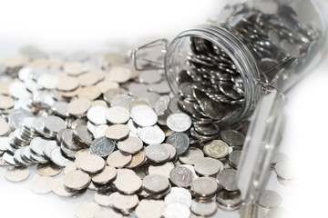 Coins in glass jar for money saving on the table.