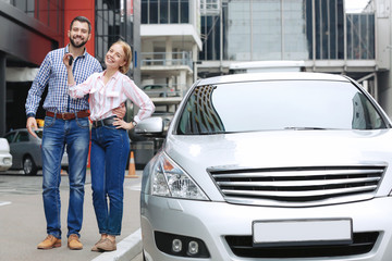 Obraz premium Young couple standing near car outdoors