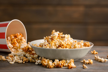 Bowl with tasty caramel popcorn on wooden table