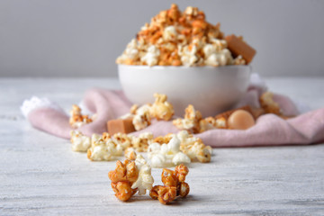 Fototapeta na wymiar Tasty caramel popcorn on white wooden table