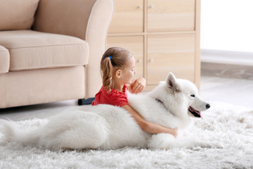 Cute little girl with dog at home