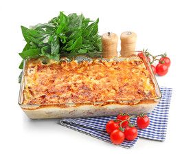 Potato casserole in baking dish, tomatoes and basil, isolated on white