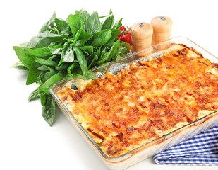 Potato casserole in baking dish and basil, isolated on white