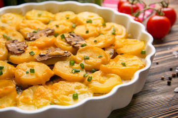 Delicious potato casserole in baking dish on wooden table