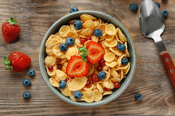 Dish with cornflakes and berries on table