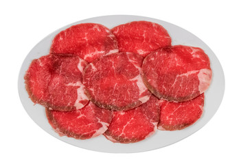 raw beef fillets on a plate .