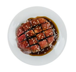 raw beef fillets on a plate .