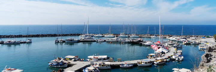 Fototapeta na wymiar View on port of Vlichada town full with small fishing boats at Santorini island