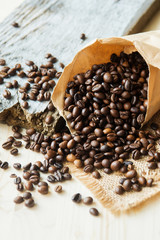 Close up roasted coffee beans in paper bags on wooden background
