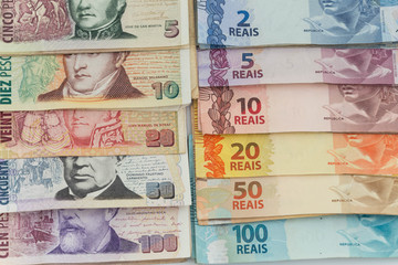 Brazilian money and Argentinian peso  / business concept