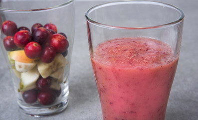 Fruit smoothies with blueberries, raspberries, apple, orange , pear and banana on  gray background