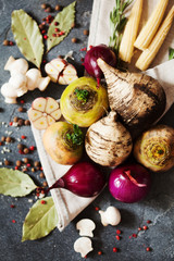 Fresh vegetables and spices for vegan soup. Turnip, radish, onion, champignon, garlic on dark slate background