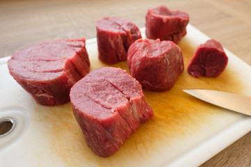 Rohes Rinderfilet in Stücken auf Schneidebrett