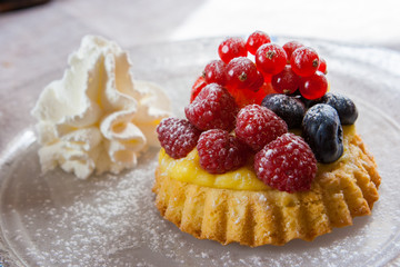 Small tartelette, dessert with blueberries, raspberries and cream. Cortina D'Ampezzo, Dolomites, Italy.