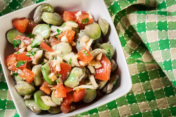 Broad bean salad with tomatoes, onion and olive