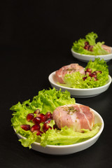 goat cheese with bacon on a frisee lettuce leaf with pomegranate as garnishing