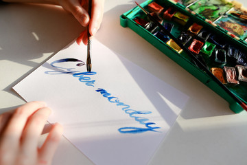 Female calligrapher creates inscription for sale, using brushes 
