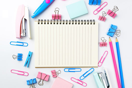 Stationary concept, Flat Lay top view Photo of school supplies scissors, pencils, paper clips,calculator,sticky note,stapler and notepad in pastel tone on white background with copy space, flat lay