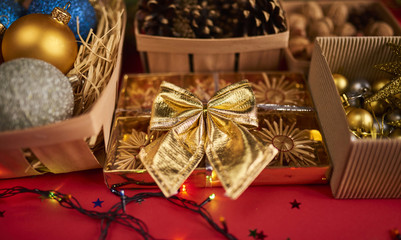 Fototapeta na wymiar Christmas decorations, pine cones and nuts in boxes on red backround