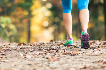 Woman walking and hiking in autumn forest